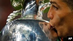 Le joueur portugais Cristiano Ronaldo embrasse la coupe de l'Euro 2016 après avoir battu la France en finale le 10 juillet 2016.