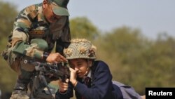FILE - An Indian army soldier shows the functions of a gun to a schoolgirl during an awareness programme to attract youth in joining the armed forces on the eve of India's Republic Day at Gandhinagar, in the western state of Gujarat, India, Jan. 25, 2016.