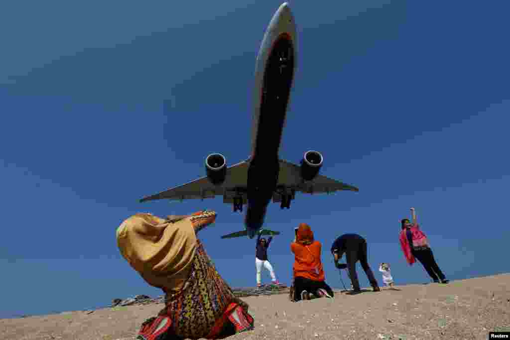 Puket Havalimanı&#39;nda yaklaşan uçağın fotoğrafını çeken turistler.