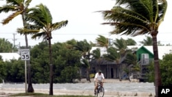 A cyclist rides his bike in Key West, Florida, Sunday, Aug. 26, 2012. Tropical Storm Isaac gained fresh muscle Sunday as it bore down on the Florida Keys, with forecasters warning it could grow into a dangerous Category 2 hurricane as it nears the norther