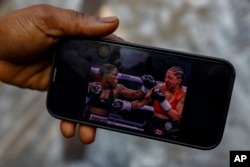 Abigail Kwartekaa Quartey, 28, shows a photo of her match against Sangeeta Birdie from Britain, which earned her the world title and made her Ghana's first-ever female world boxing champion in Jamestown, Accra, Ghana, Jan 23, 2025.