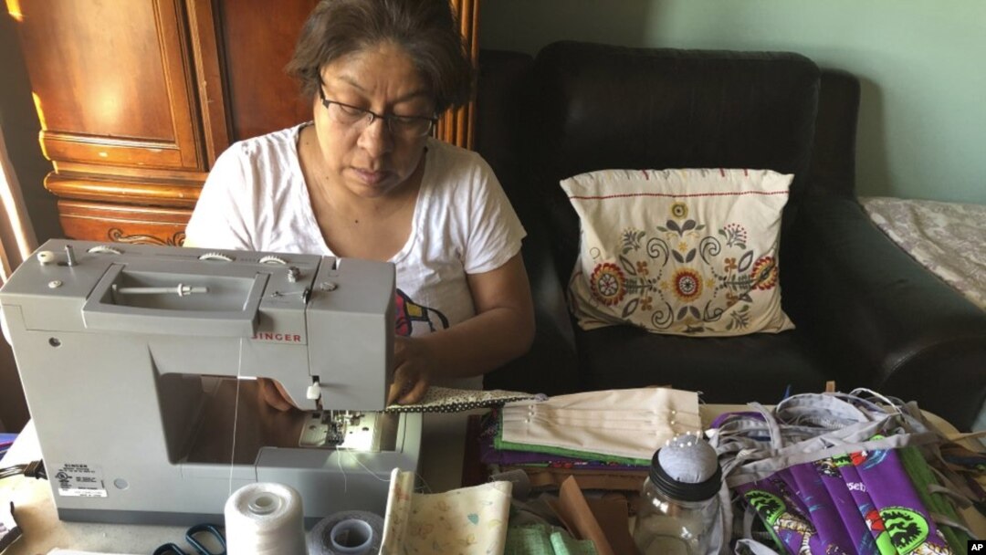 En esta imagen del 7 de abril, Maribel Torres hace mascarillas en su casa de Staten Island, Nueva York. Antes limpiaba apartamentos, pero dejaron de llamarla cuando empezó la pandemia.