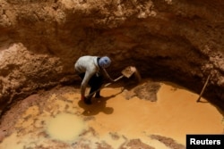 A man digs to search for water in a dry river bed near the village of Tata Bathily in Matam, Senegal on March 30, 2022. (REUTERS/Ngouda)