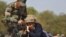 FILE - An Indian army soldier shows the functions of a gun to a schoolgirl during an awareness programme to attract youth in joining the armed forces on the eve of India's Republic Day at Gandhinagar, in the western state of Gujarat, India, Jan. 25, 2016.