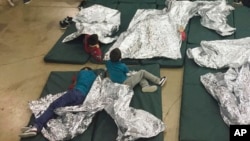 FILE - Children who've been taken into custody related to cases of illegal entry into the United States rest in one of the cages at a facility in McAllen, Texas, June 17, 2018.