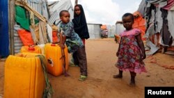 Somali children stand outside their makeshift shelter at a camp for the internally displaced people outside Mogadishu, Somalia August 28, 2018 .