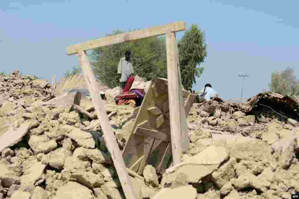 Pakistani survivors gather around their destroyed houses in the earthquake-devastated district of Awaran.