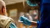 FILE- A man receives a dose of a COVID-19 vaccine from a health worker, in Wilkesboro, North Carolina, Feb. 2, 2021.