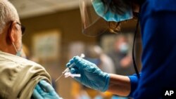 နယူးယောက်မြို့မှာ အမျိုးသားတဦးကို ကိုဗစ်ကာကွယ်ဆေး ထိုးပေးနေတဲ့ ကျန်းမာရေးဝန်ထမ်း။ (ဖေဖော်ဝါရီ ၂၊ ၂၀၂၁)