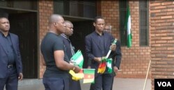 Men hand out flags to people praying for peace in Cameroon's restive English-speaking regions, at Saint Joseph's Anglophone Parish in Cameroon's capital, Yaounde, Sept. 6, 2019. (M.Kindzeka/VOA)