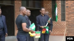 FILE - Men hand out flags to people praying for peace in Cameroon's restive English-speaking regions, at Saint Joseph's Anglophone Parish in Cameroon's capital, Yaounde, Sept. 6, 2019. (M.Kindzeka/VOA)