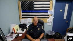 FILE - Taunton police Lt. Paul Roderick sits behind his desk at police headquarters in Taunton, Mass., July 11, 2017. 
