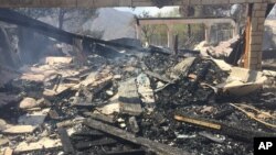 The remains of a burned home smoulder in Iron Canyon Road area near Santa Clarita, California, on Sunday, July 24, 2016.