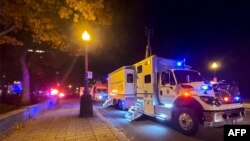 A Police truck is parked near the National Assembly of Quebec, in Quebec City, Nov. 1, 2020, after two people were killed and five wounded by a sword-wielding suspect dressed in medieval clothing.