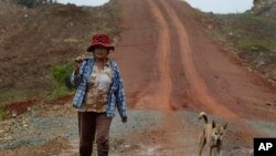 A Cambodian woman carries a long-handled machete as she travels on a road in Thmey village, Koh Kong province, about 250 kilometers (155 miles) west of Phnom Penh, file photo. 