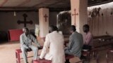 FILE - The Rev. Yousef Zamgila, left, a Lutheran pastor, speaks to members of his congregation at the improvised church they helped set up in Omdurman, Khartoum’s twin city, Aug. 22, 2019. 