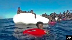 Screenshot video penjaga pantai Italia menunjukkan migran Afrika yang terapung-apung di Laut Tengah setelah kapal mereka tenggelam, Sabtu (6/1). 