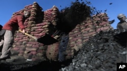 Afghan laborers work at a charcoal shop in Kabul, Afghanistan, Nov. 16, 2015. In the winter, prices of wood and charcoal rise among all other necessities for Afghans.