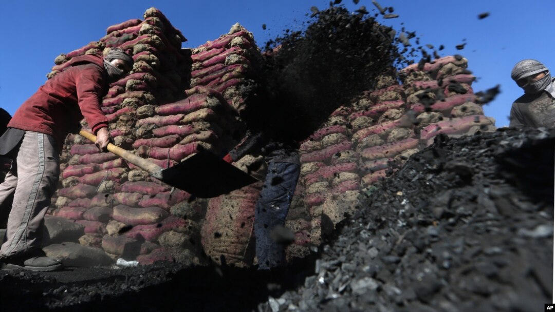 Afghan laborers work at a charcoal shop in Kabul, Afghanistan, Nov. 16, 2015. In the winter, prices of wood and charcoal rise among all other necessities for Afghans.