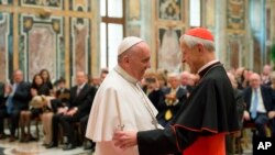 FILE - Pope Francis, left, talks with Papal Foundation Chairman Cardinal Donald Wuerl, Archbishop of Washington, D.C., during a meeting with members of the Papal Foundation at the Vatican, April 17, 2015. 