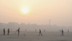 People play cricket on the floodplains of the Yamuna river on a smoggy morning in New Delhi, India, Nov. 17, 2021.