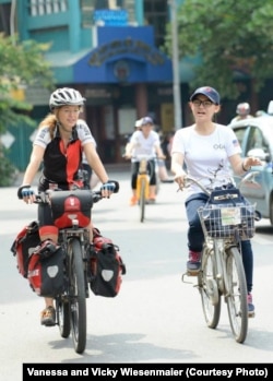 Vicky Wiesenmaier chats with a Vietnamese woman during a ride in Hanoi.