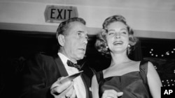 Humphrey Bogart ພ້ອມດ້ວຍພັນລະຍາ Lauren Bacall ໄດ້ໄປຮ່ວມ ພິທີເປີດໂຕຮູບເງົາ Hollywood 'The Desperate Hours' ຮອບປະຖົມມະເລີກ ເມື່ອວັນທີ 12 ຕຸລາ 1955. 