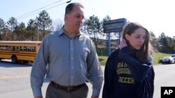 Jenna Mickel (kanan), seorang siswi di Franklin Regional High School, Murrysville, dijemput oleh ayahnya setelah insiden penusukan terjadi di sekolah tersebut.