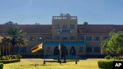 The Zimbabwean flag flies at half mast at Kutama College, a school where former Zimbabwean President Robert Mugabe studied in his rural home in Zvimba about 100 kilometres north west of the capital Harare, Friday, Sept, 27, 2019. 