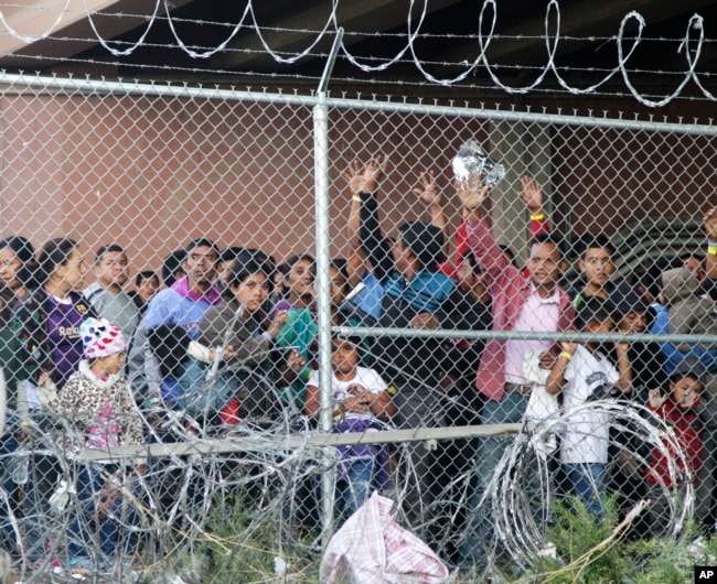 Central American migrants wait for food in El Paso, Texas, March 27, 2019, in a pen erected by U.S. Customs and Border Protection to process a surge of migrant families and unaccompanied minors.