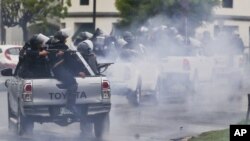 En esta imagen de archivo, tomada el 28 de mayo de 2018, policías con equipos antimotines, montados en la parte trasera de varias camionetas, disparan contra estudiantes universitarios que protestan contra el presidente de Nicaragua, Daniel Ortega, en Managua. (AP Foto / Esteban Félix, archivo)