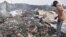 Les habitants ramassent les restes de leurs maisons détruites après l'éruption du volcan du mont Nyiragongo près de Goma, en RDC, le 23 mai 2021.