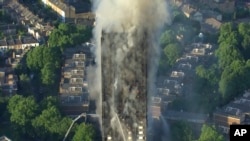 In this photo taken from video, smoke rises from a high-rise apartment building on fire in London, June 14, 2017. 
