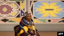 South African visual artist Esther Mahlangu sits in front of her artwork during an interview ahead of the influential Ndebele artist’s major new retrospective opening at the Iziko South African National Gallery in Cape Town, on February 17, 2024. 