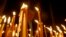 FILE - A man lights candles during a religious service marking the anniversary of mass killings of Armenians in Ottoman Empire in 1915 at an Armenian church in Tbilisi, Georgia.