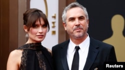 Mexican director Alfonso Cuaron, best director nominee for his film "Gravity," and his partner Sheherazade Goldsmith arrive at the 86th Academy Awards in Hollywood, California, March 2, 2014. 