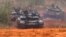 FILE - Russian tanks advance during the Zapad 2017 military exercises near St. Petersburg, Russia, Sept. 18, 2017.