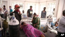 Para pasien menggunakan tabung oksigen di sebuah rumah sakit setelah kebocoran pabrik oksigen di Nashik, negara bagian Maharastra, India, 21 April 2021. (Foto: AP)