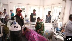 Para pasien menggunakan tabung oksigen di sebuah rumah sakit setelah kebocoran pabrik oksigen di Nashik, negara bagian Maharastra, India, 21 April 2021. (Foto: AP)