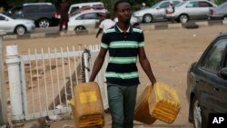 Un homme porte des bidons d'essence à Abuja, Nigeria, le 26 mai 2015. (AP Photo/Sunday Alamba)