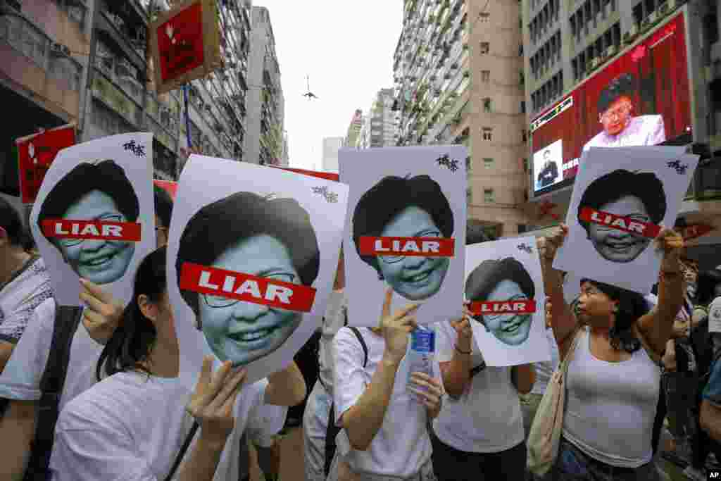 معترضان هنگ کنگی با تصاویری از &laquo;کری لم&raquo; مدیر اجرایی هنگ کنگ که روی آن نوشته &laquo;دروغگو&raquo;. معترضان می گویند قانون جدید باعث استرداد متهمان به چین می شود و به آن اعتراض دارند.&nbsp;