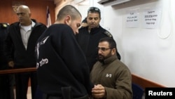 សមាជិក​នៃ​ក្រុម​សកម្ម​ប្រយុទ្ធ​ Hamas ឈ្មោះ Hussam Hassan Kawasame (ស្តាំ) អង្គុយ​នៅ​ក្នុង​តុលាការ​យោធា​ Ofer នៅ​តបន់​ West Bank នៃ​ក្រុង ​Ramallah កាល​ពីថ្ងៃ​ទី​៦ ខែ​មករា ឆ្នាំ២០១៥។ 