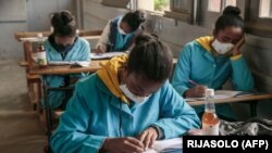 Une bouteille de Covid Organics devant un élève du lycée J.J. Rabearivelo, dans le centre d'Antananarivo, le 23 avril 2020. (Photo: RIJASOLO / AFP)