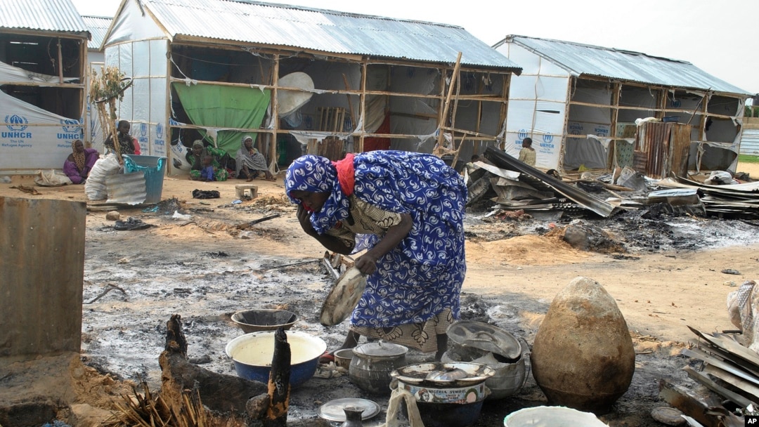 A woman salvages cooking pots at the site of an explosion in Maiduguri, Nigeria, June 8, 2017. Authorities in northeast Nigeria say at least 14 people are dead and dozens are wounded after Boko Haram militants launched a series of attacks.