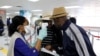 Travelers arriving into Haiti at the International Airport Toussaint Louverture get their temperature checked by a worker of the Haitian Public Health and Population Ministry (MSPP).