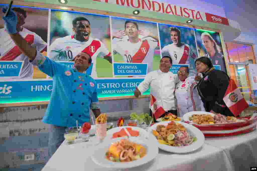 Chef dari Peru, Roberto Madrid, berswafoto dengan rekan sesama chef di samping poster pesepak bola nasional dan berbagai sajian makanan di sebuah restoran di Lima, 11 Juni 2018. Gastronomi Peru meracik masakan khas untuk menyesuaikan dengan Piala Dunia FIFA yang akan dimulai 14 Juni. (Foto: AFP)