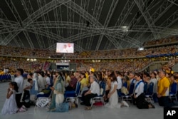 Umat menanti di Stadion Nasional Singapore SportsHub tempat Paus memimpin misa di Singapura, Kamis, 12 September 2024. (Foto: AP)