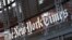 FILE - A sign for The New York Times hangs above the entrance to its building, May 6, 2021, in New York.