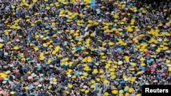 2019年6月9日在中国香港，示威群众要求当局废除拟议中的把犯人引渡到中国的法案。他们手持黄色遮阳伞，这是过去的占领中环运动的象征。