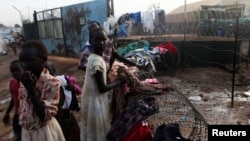 South Sudanese girls displaced by the fighting collect their laundry from a barbed wire in a camp for displaced persons in the UNMISS compound in Tongping in Juba February 19, 2014. Thousands of people have been killed and more than 800,000 have fled thei